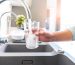 Close up of a woman hand filling a glass of water directly from the tap. High resolution 42Mp indoors digital capture taken with SONY A7rII and Zeiss Batis 25mm F2.0 lens